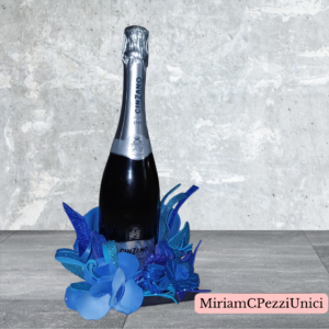 porta bottiglia_centro tavola oro con decorazioni e fiori blu_senza bottiglia
